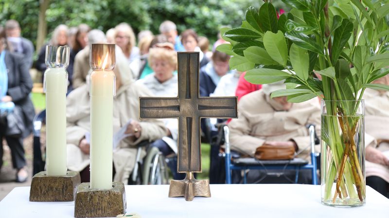 Kerzen und Kreuz auf dem Altar beim Sommersegen auf dem Stiftungsgelände